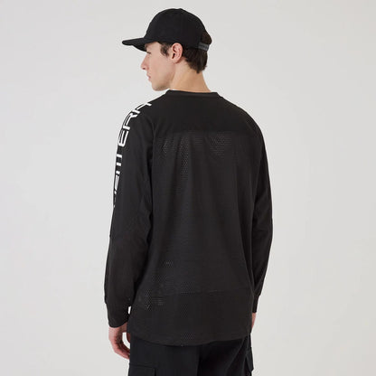 The model is wearing this New Era NEC Logo Long Sleeve Jersey in black. 2