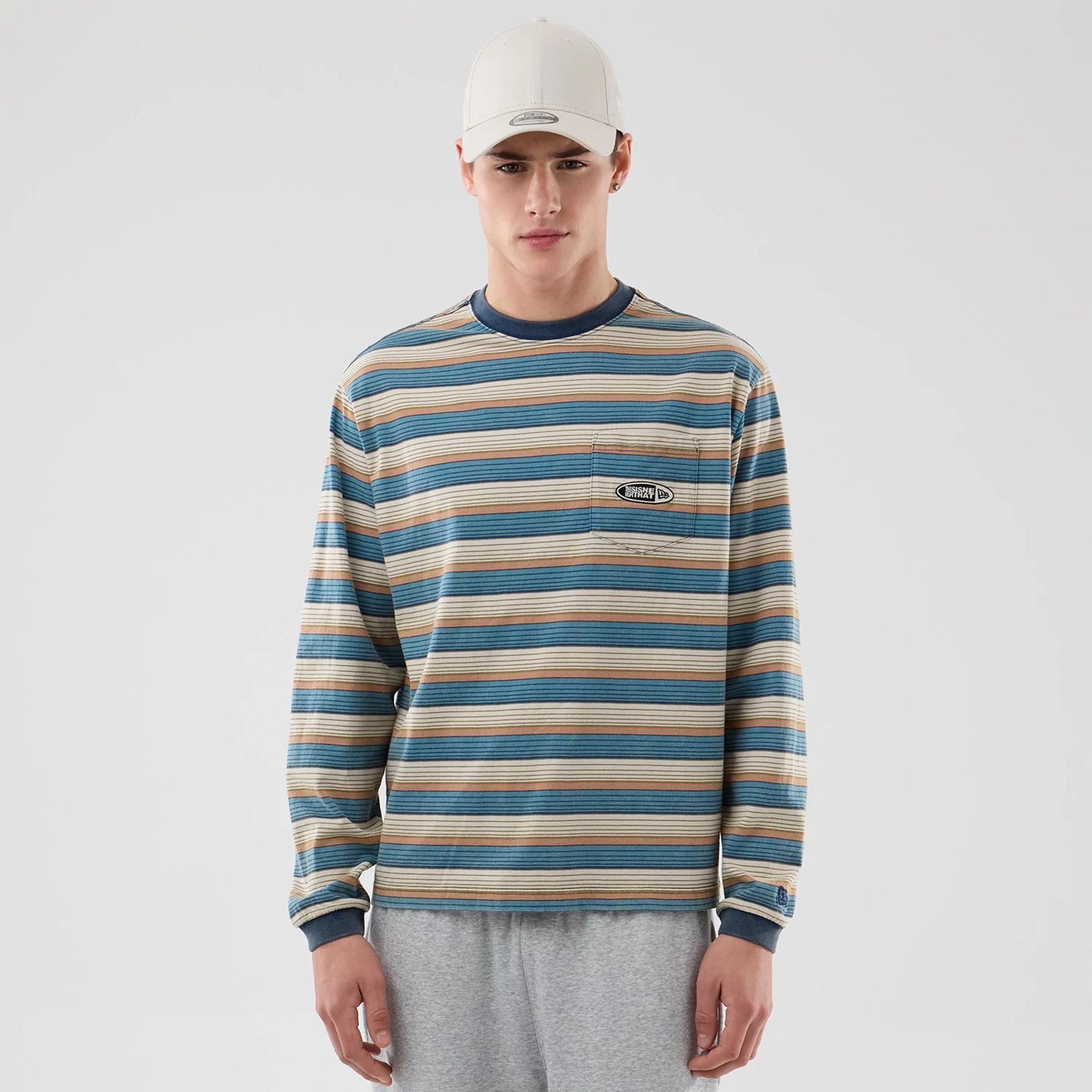 The model is wearing this Thisisneverthat X New Era Border Long Sleeve T-Shirt in beige. 1