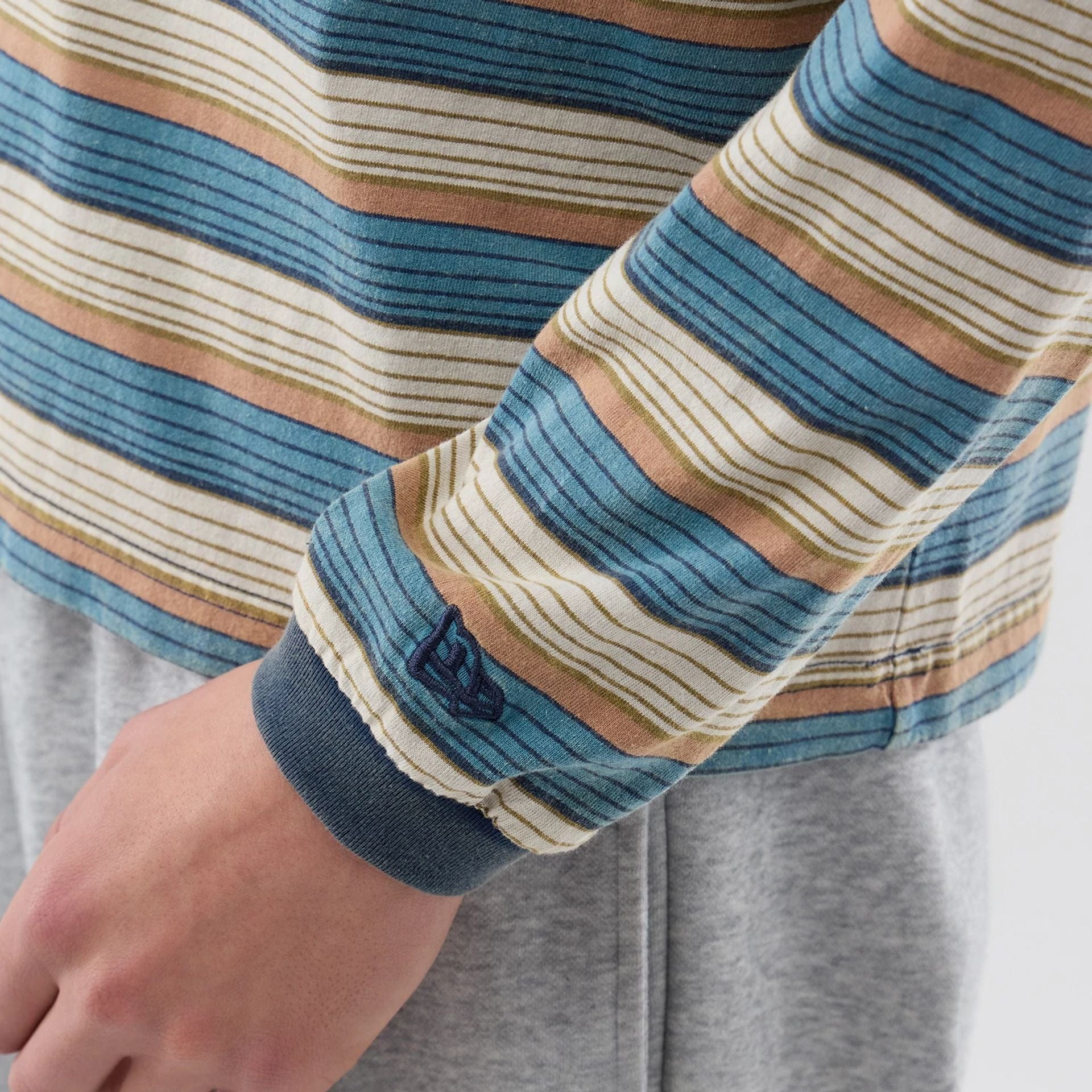 The model is wearing this Thisisneverthat X New Era Border Long Sleeve T-Shirt in beige. 4