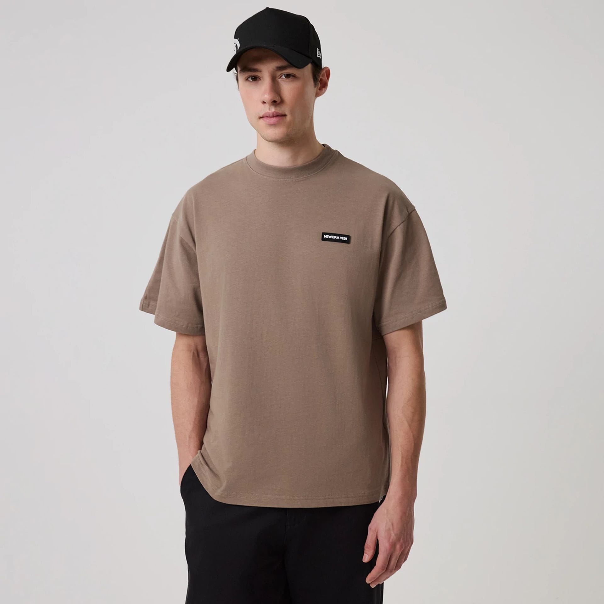 The model is wearing this New Era Distressed T-Shirt in Brown. 1