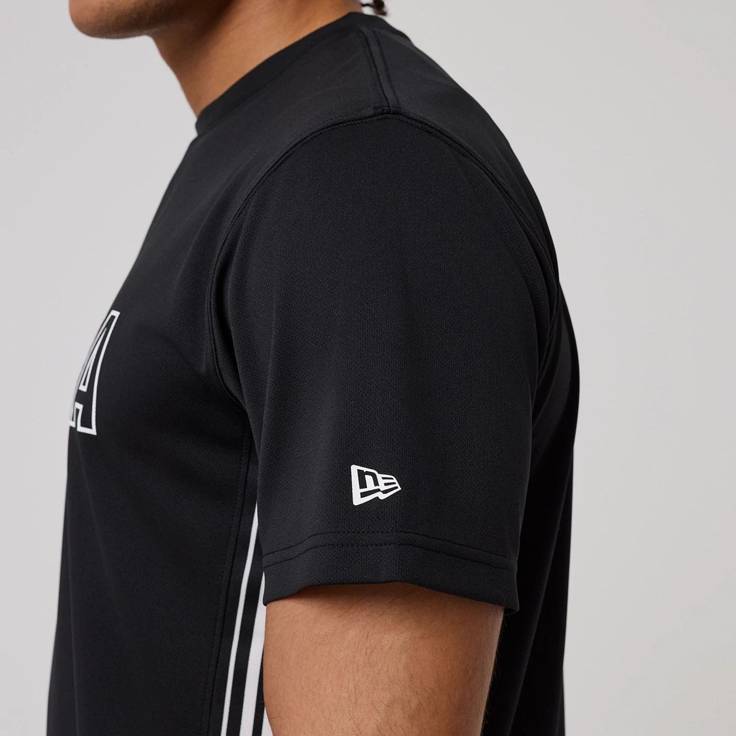 The model is wearing this New Era Mesh T-Shirt in black. 4