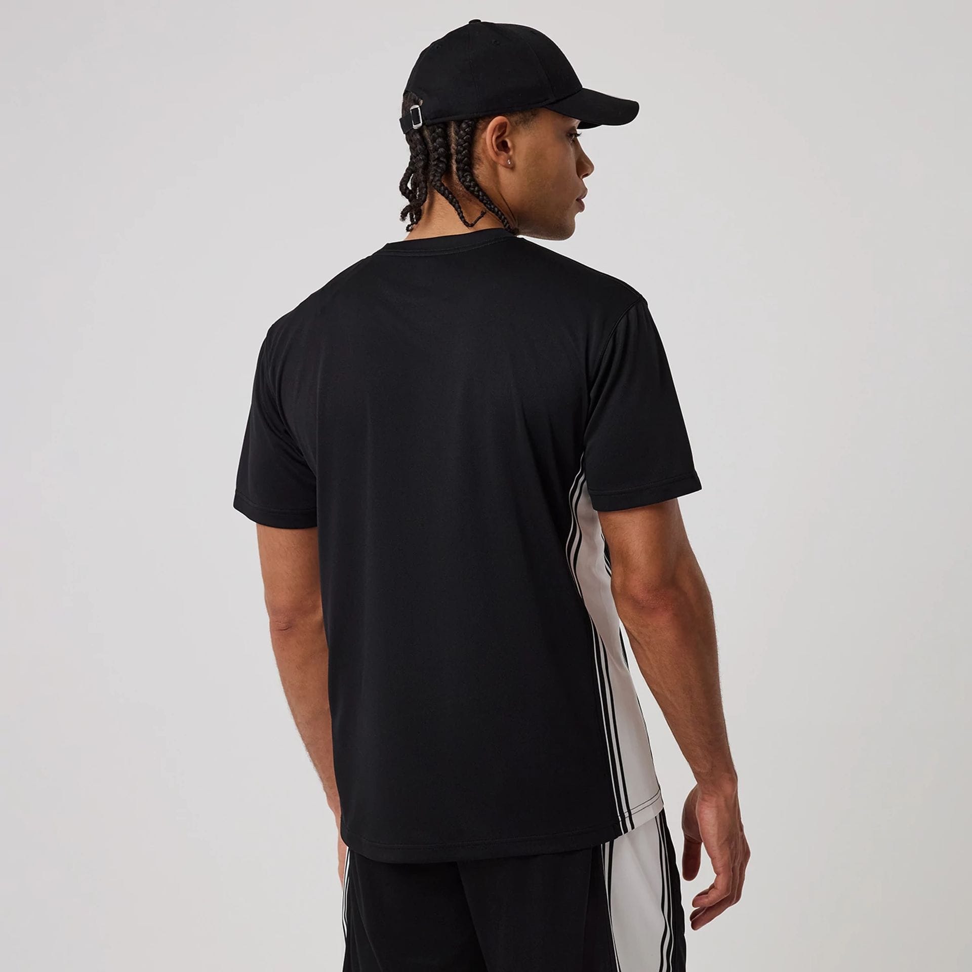 The model is wearing this New Era Mesh T-Shirt in black. 2