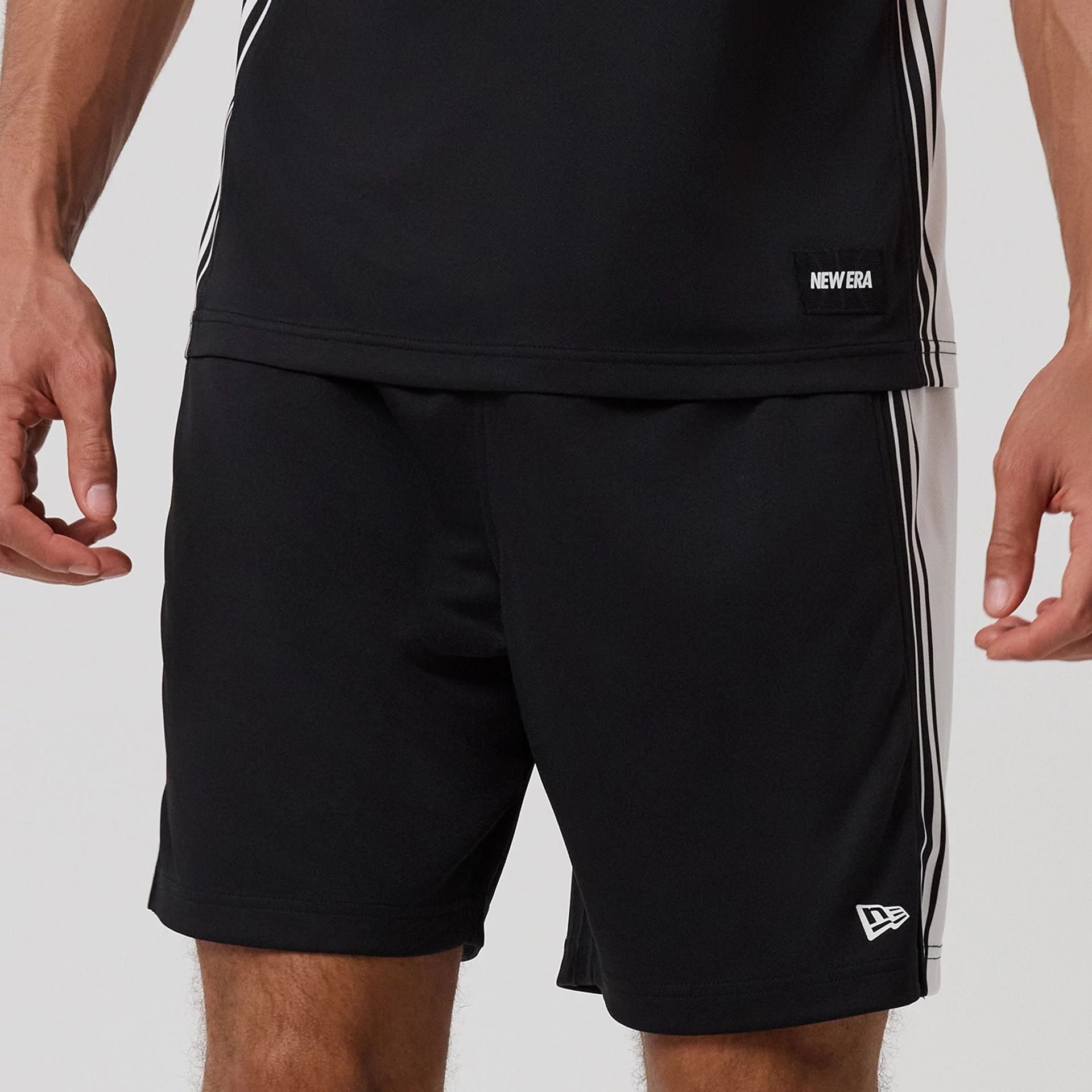 The model is wearing this New Era Mesh Oversized Shorts in black. 3