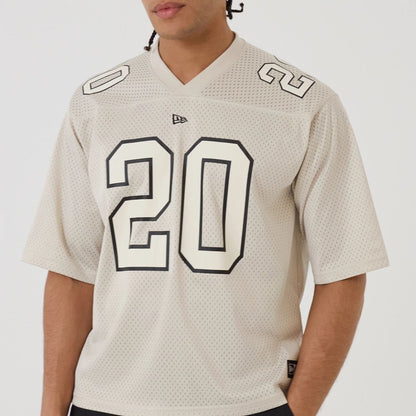 The model is wearing this New Era Mesh Football Short Sleeve Shirt in beige. 7