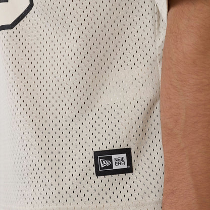The model is wearing this New Era Mesh Football Short Sleeve Shirt in beige. 6