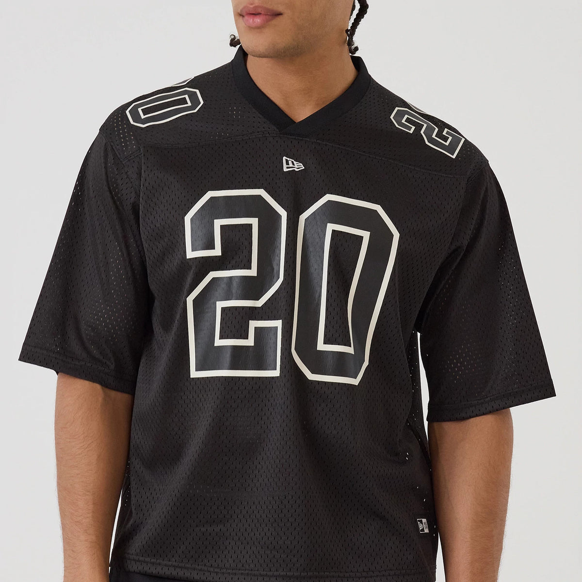 New Era Mesh Football Black Short Sleeve Shirt, front view on a model showing large white number 20 printed on the chest, with matching numbers on the shoulders and a New Era logo below the neckline.