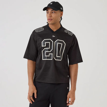 The model is wearing this New Era Mesh Football Short Sleeve Shirt in black. 1