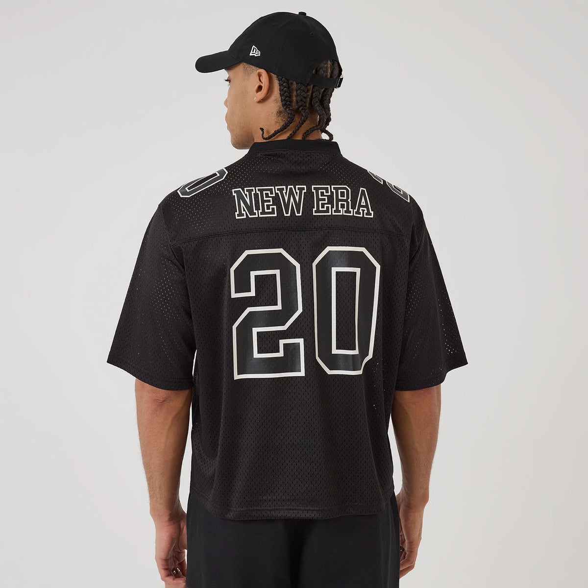 New Era Mesh Football Black Short Sleeve Shirt, back view on a model with a black cap, featuring large white outlined number 20 and New Era lettering across the shoulders on a textured mesh fabric.