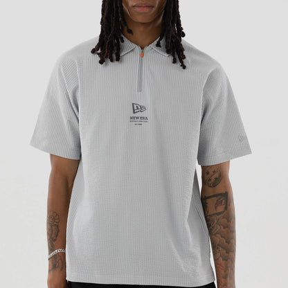 The model is wearing this New Era Seersucker Polo T-Shirt in grey. 3