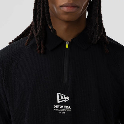 The model is wearing this New Era Seersucker Polo T-Shirt in black. 4