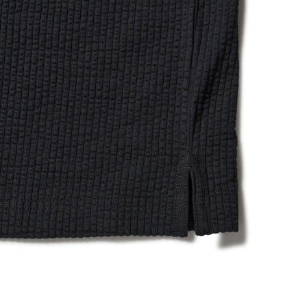 The model is wearing this New Era Seersucker Polo T-Shirt in black. 5