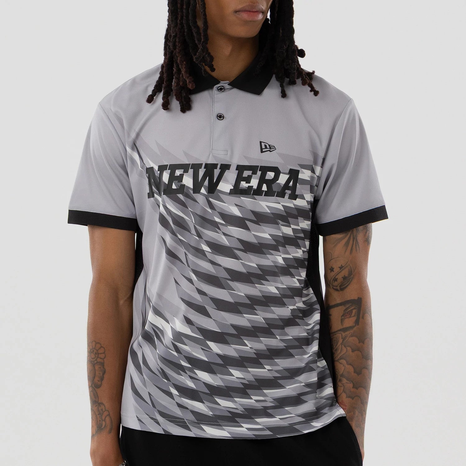 The model is wearing this New Era Grid Polo T-Shirt in grey. 3