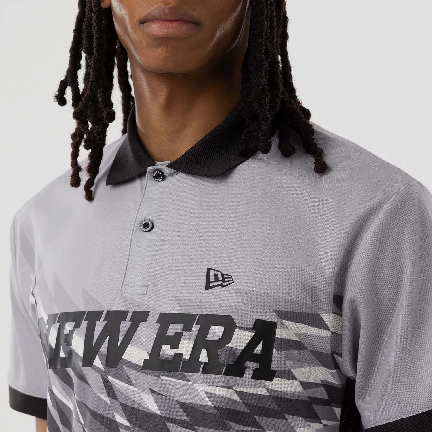 The model is wearing this New Era Grid Polo T-Shirt in grey. 5