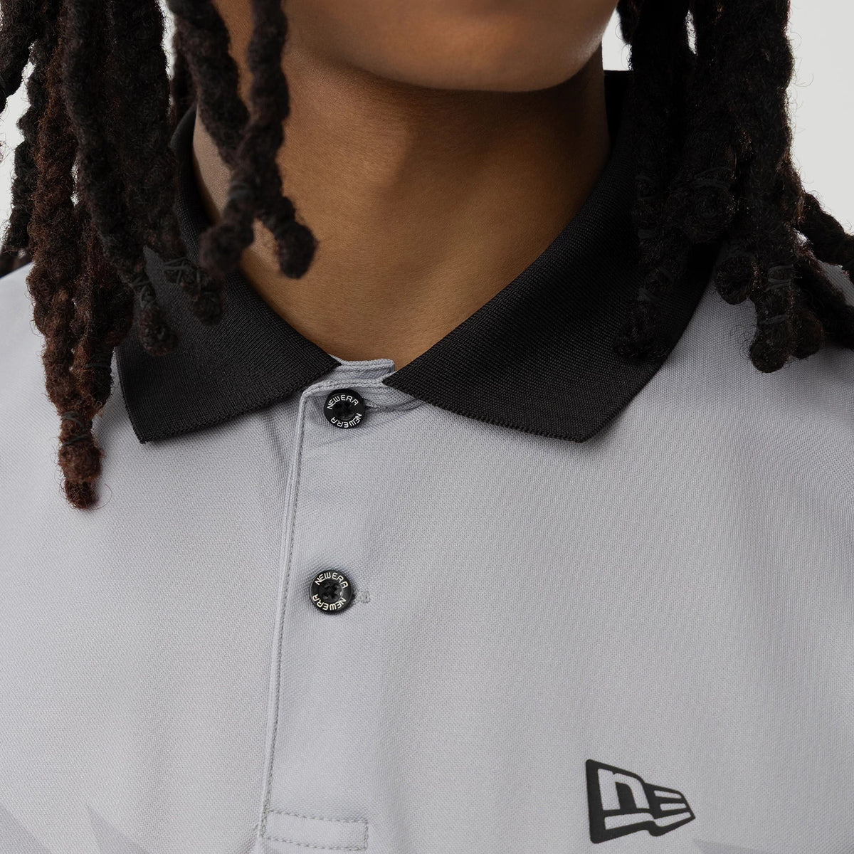 The model is wearing this New Era Grid Polo T-Shirt in grey. 6