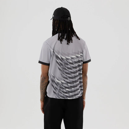The model is wearing this New Era Grid Polo T-Shirt in grey. 2