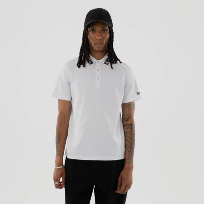 The model is wearing this New Era Kanoko Polo T-Shirt in white. 1