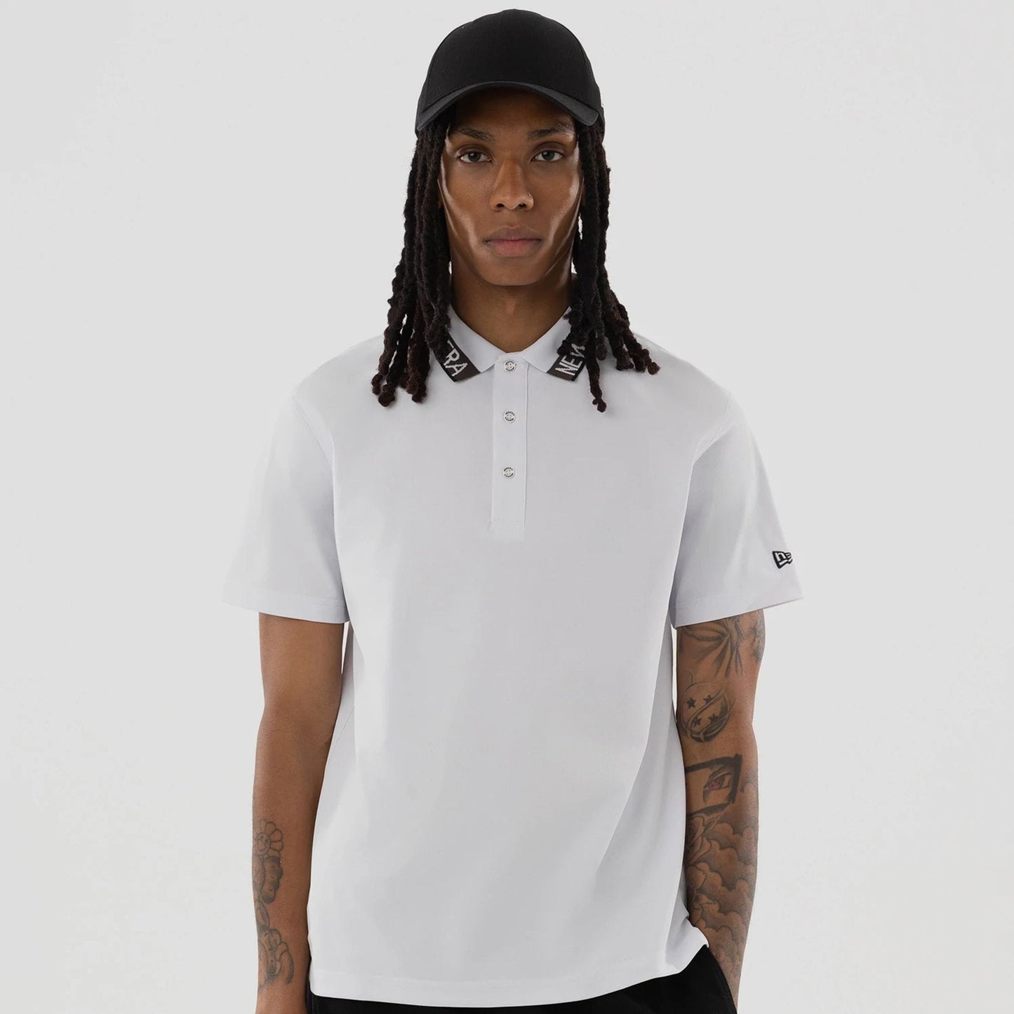 The model is wearing this New Era Kanoko Polo T-Shirt in white. 4
