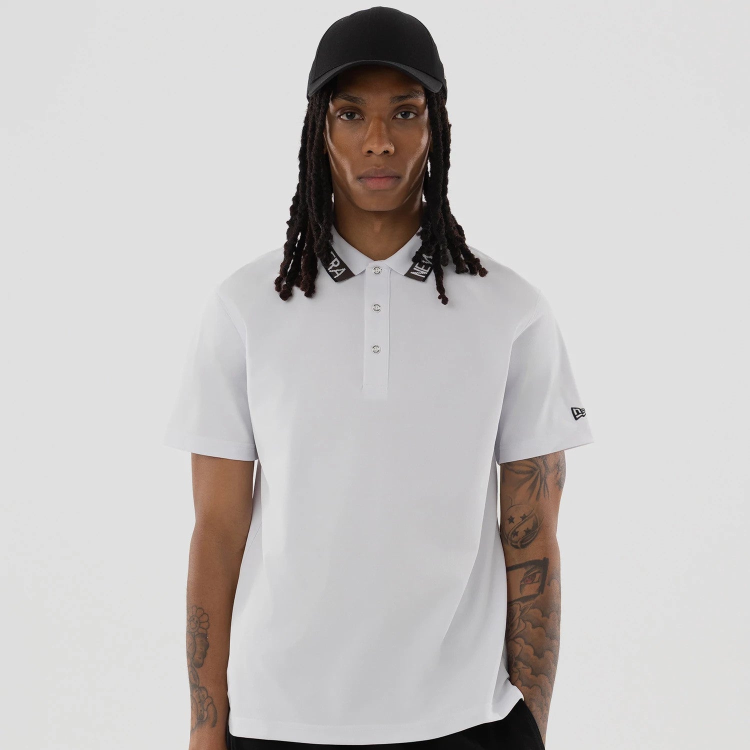 The model is wearing this New Era Kanoko Polo T-Shirt in white. 4