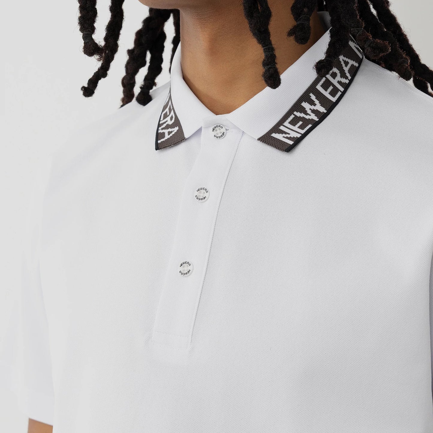 The model is wearing this New Era Kanoko Polo T-Shirt in white. 3
