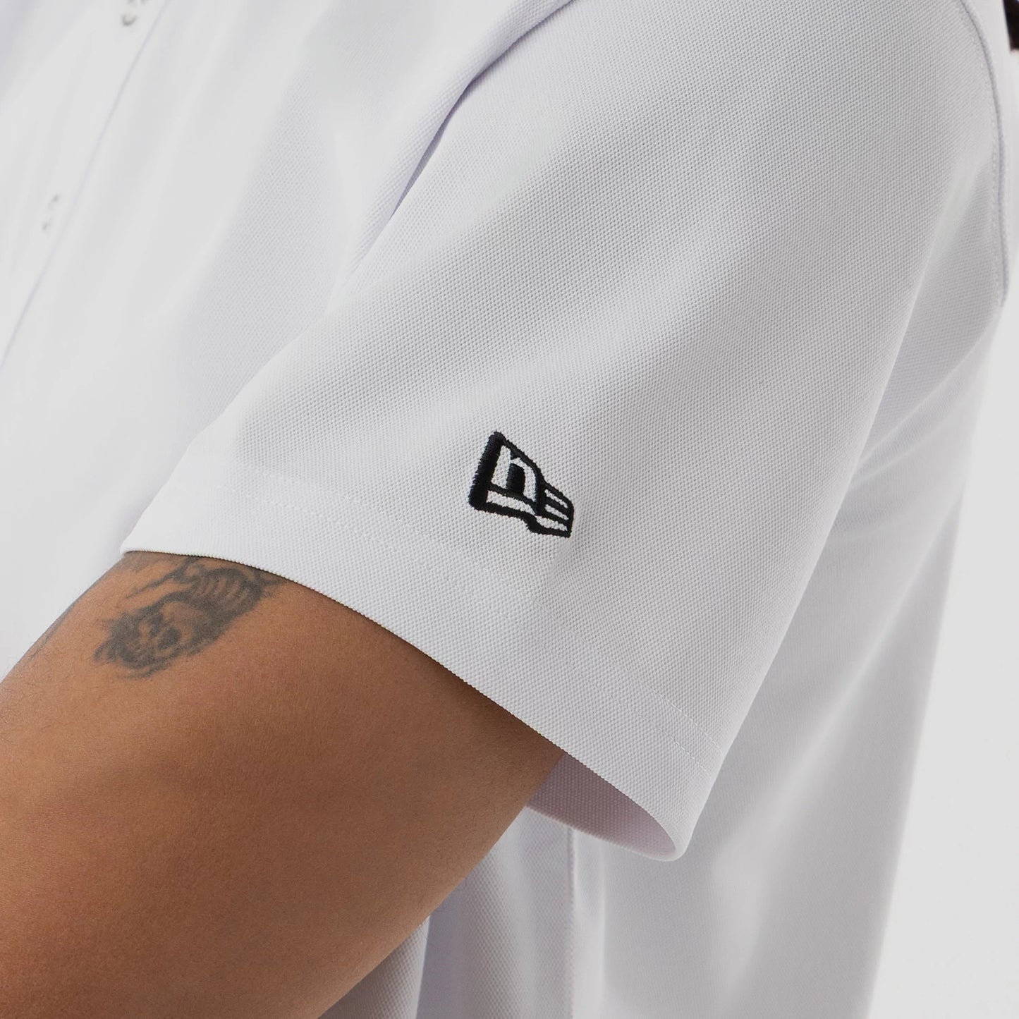 The model is wearing this New Era Kanoko Polo T-Shirt in white. 5
