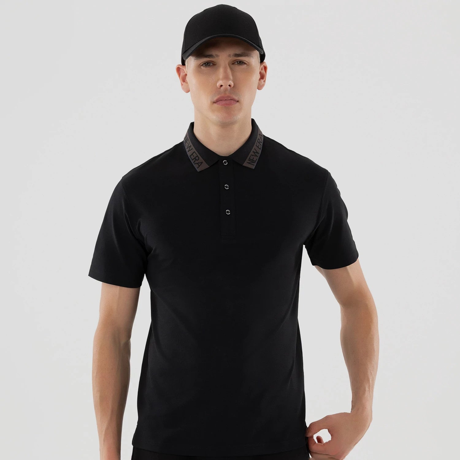 The model is wearing this New Era Kanoko Polo T-Shirt in black. 3