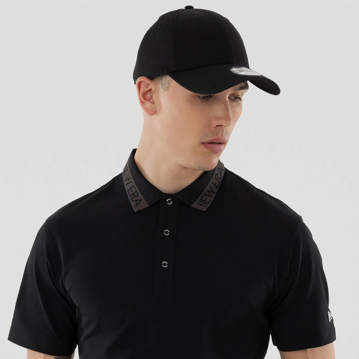 The model is wearing this New Era Kanoko Polo T-Shirt in black. 7