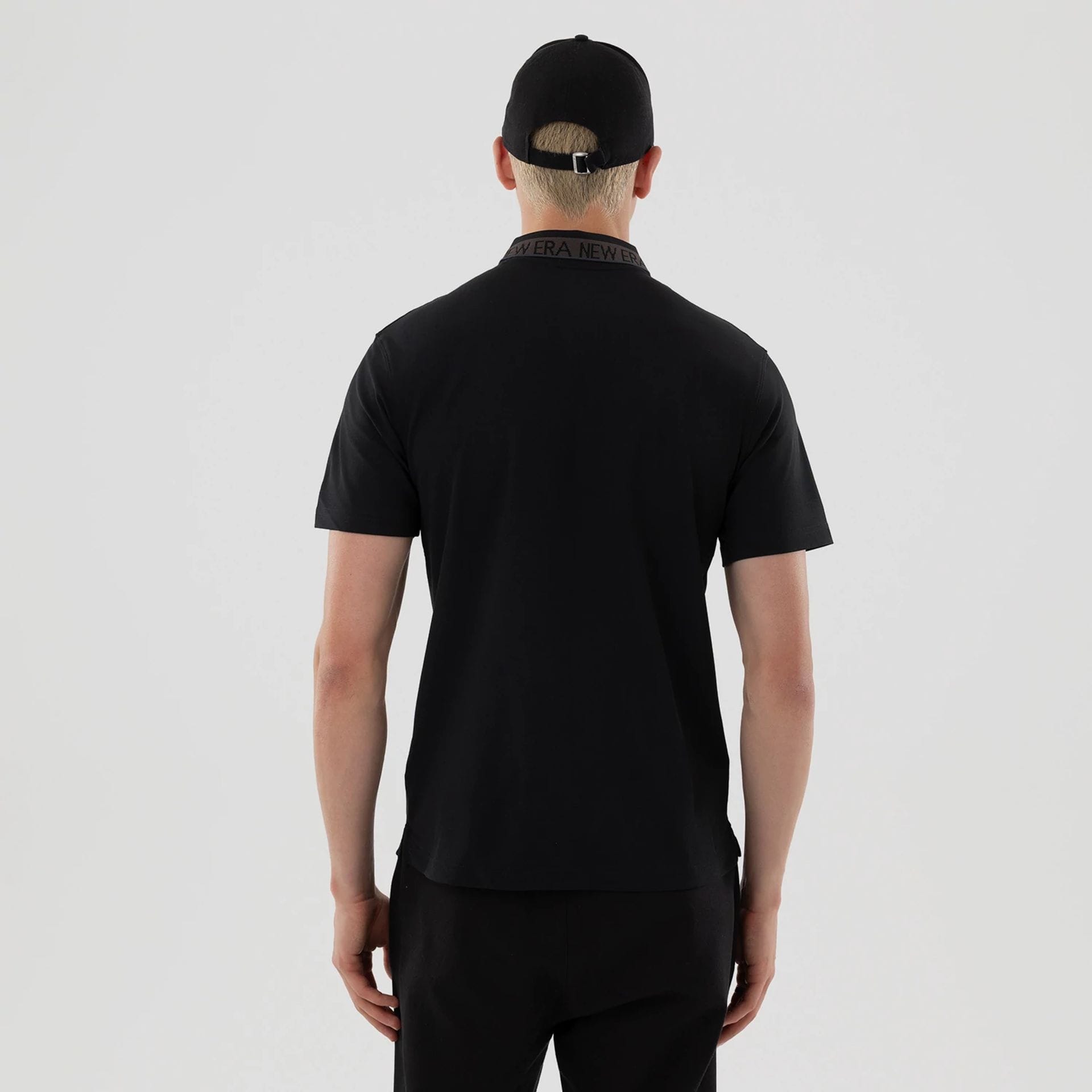 The model is wearing this New Era Kanoko Polo T-Shirt in black. 2