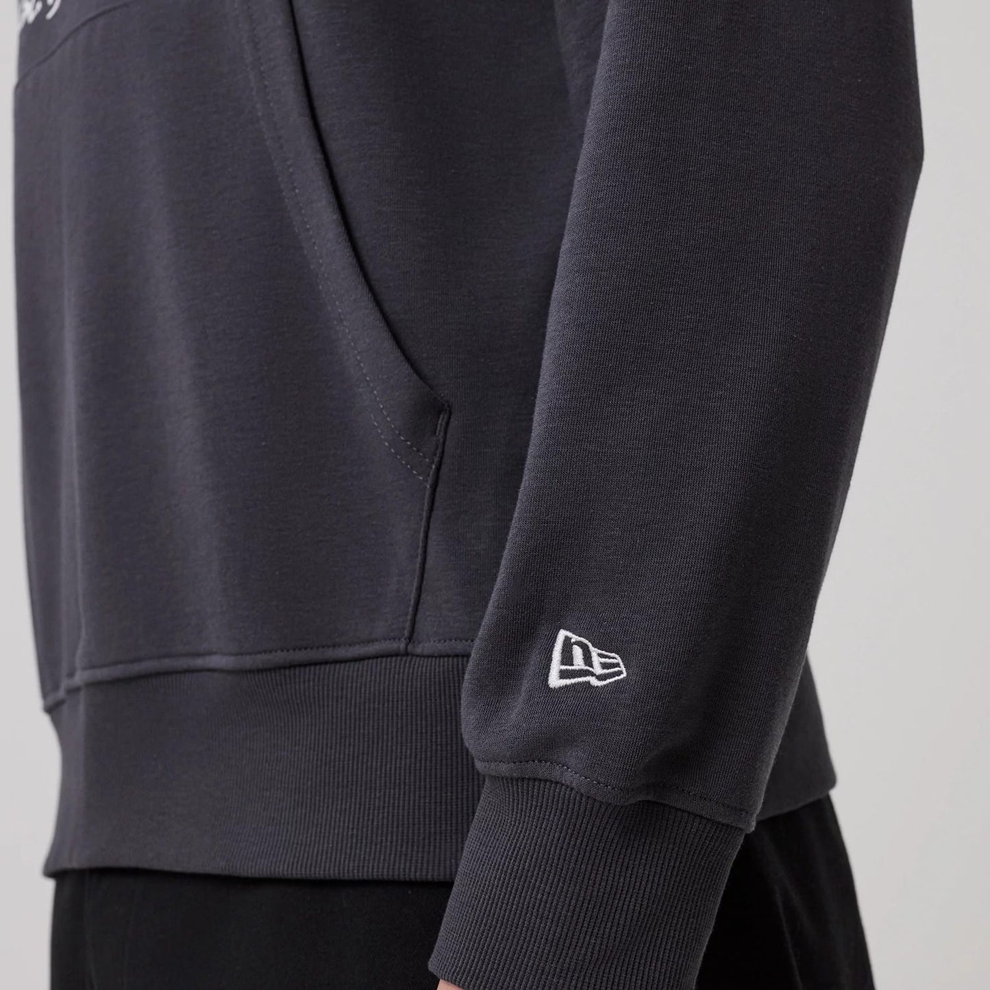 The model is wearing this New Era New York Oversized Pullover Hoodie in dark grey. 5