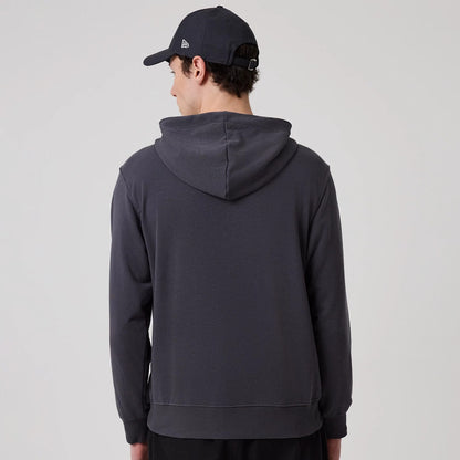 The model is wearing this New Era New York Oversized Pullover Hoodie in dark grey. 2