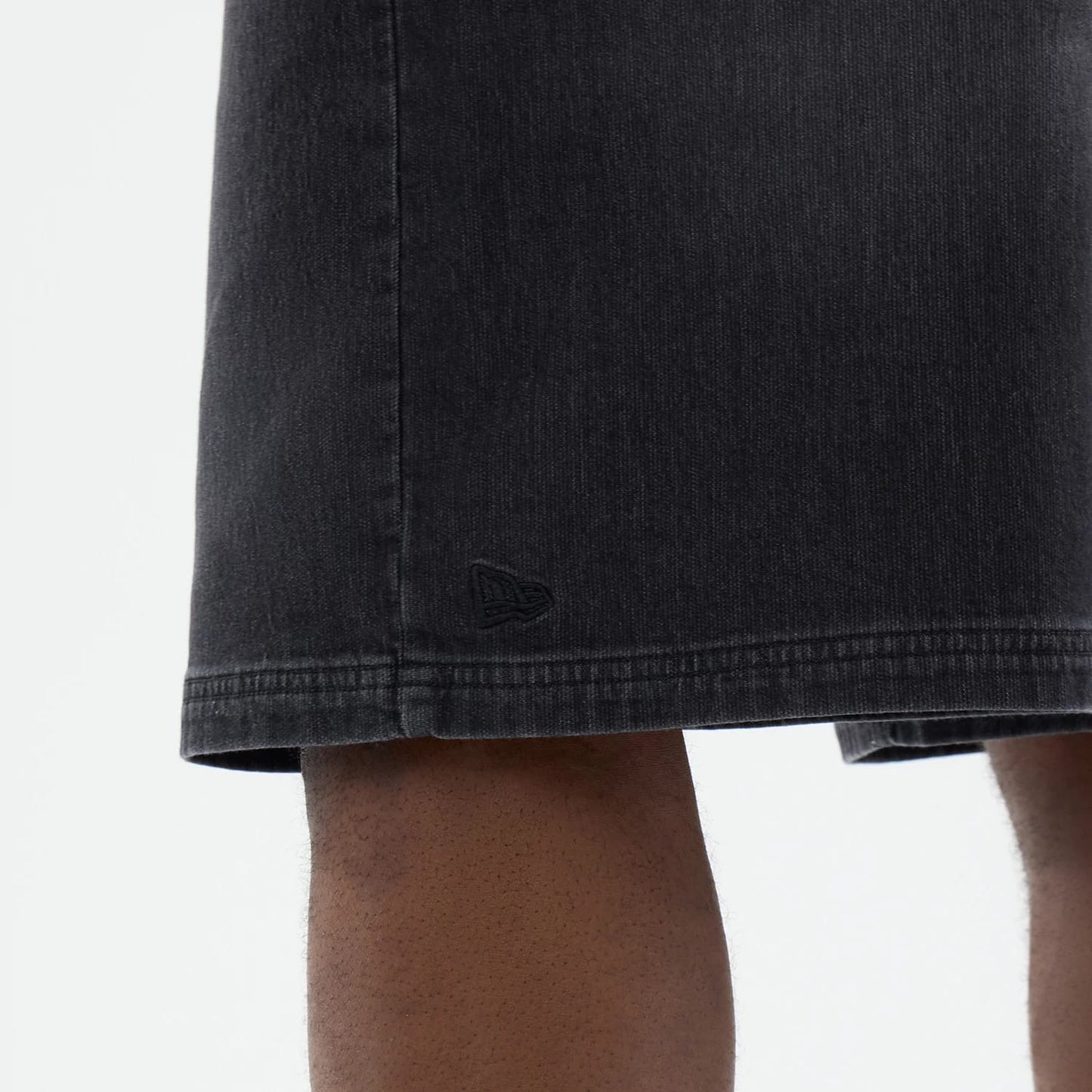 The model is wearing this New Era Washed Bermuda Shorts in black. 5