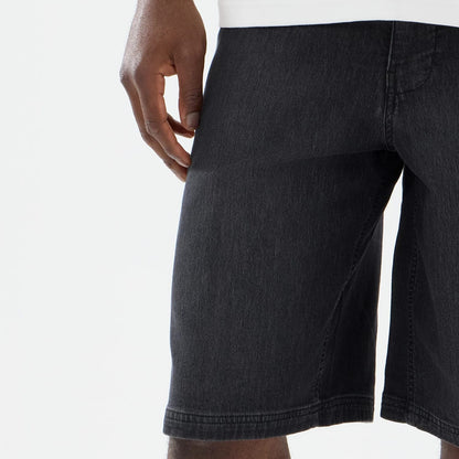 The model is wearing this New Era Washed Bermuda Shorts in black. 6