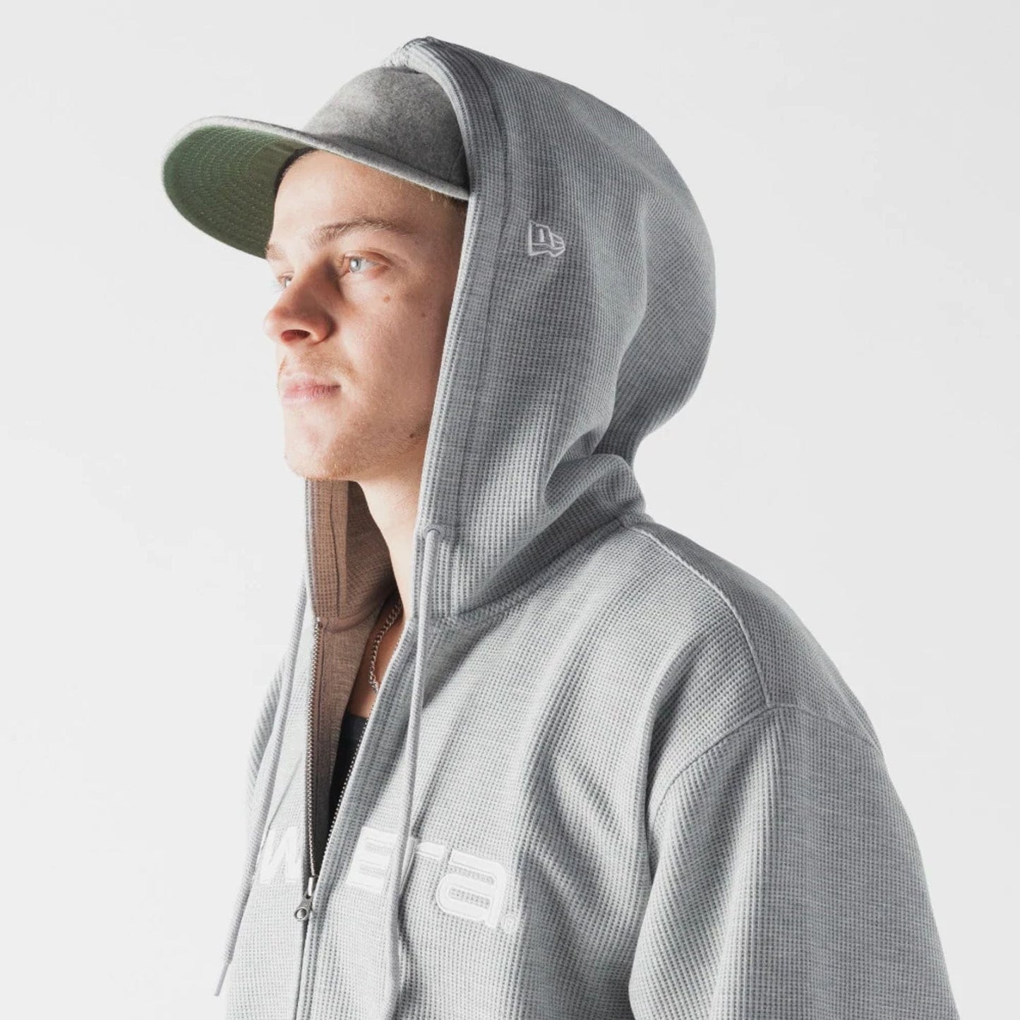 The model is wearing this New Era Waffle Full Zip Hoodie in grey. 5