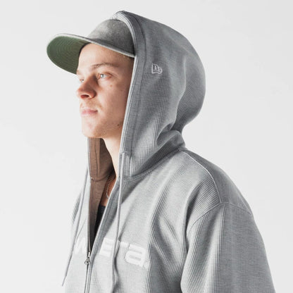The model is wearing this New Era Waffle Full Zip Hoodie in grey. 5