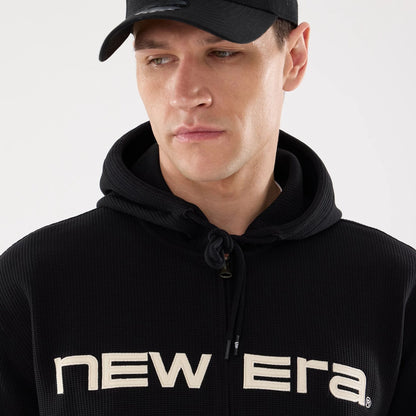 The model is wearing this New Era Waffle Full Zip Hoodie in black. 3