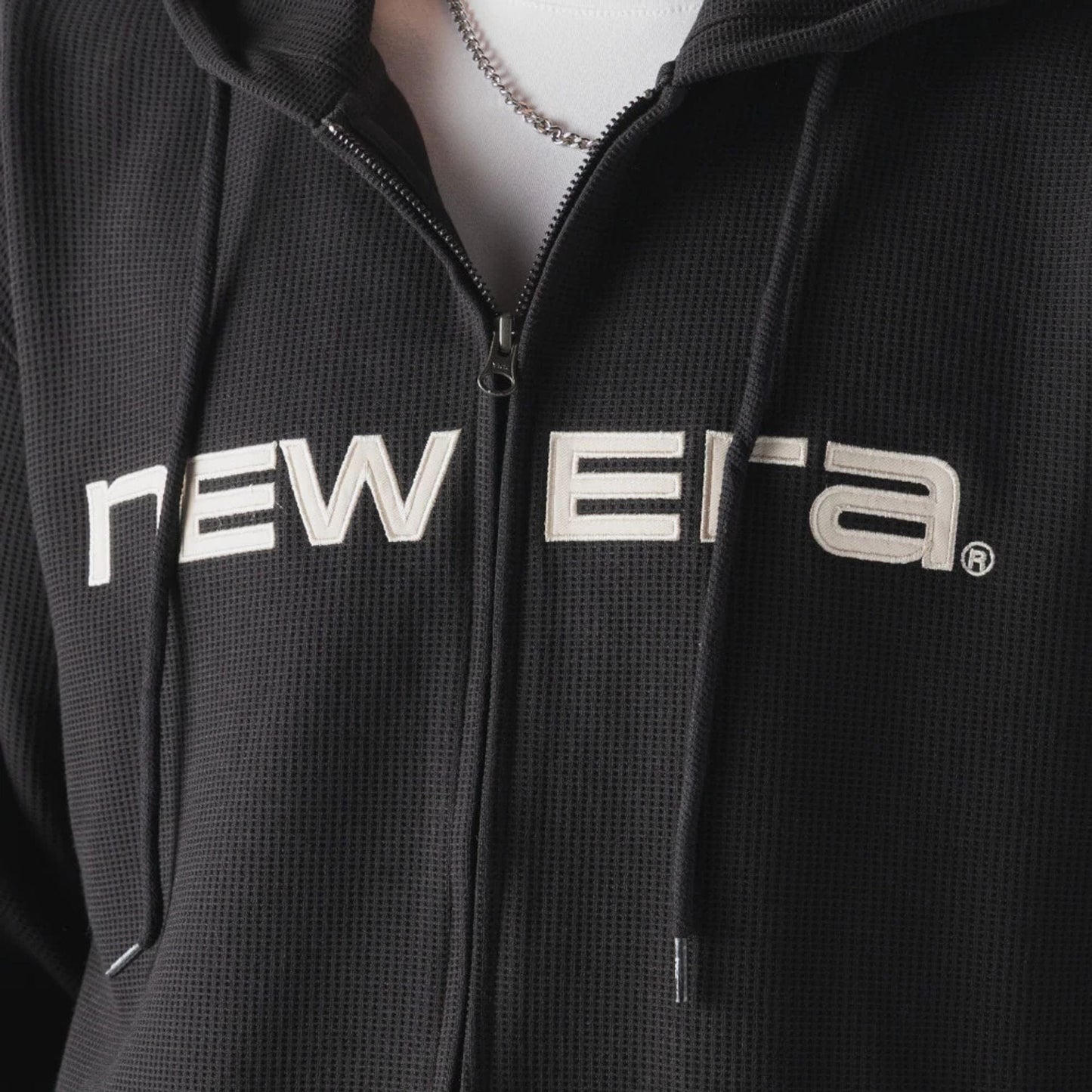 The model is wearing this New Era Waffle Full Zip Hoodie in black. 3