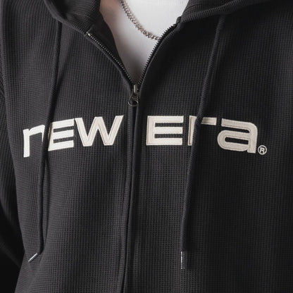 The model is wearing this New Era Waffle Full Zip Hoodie in black. 3