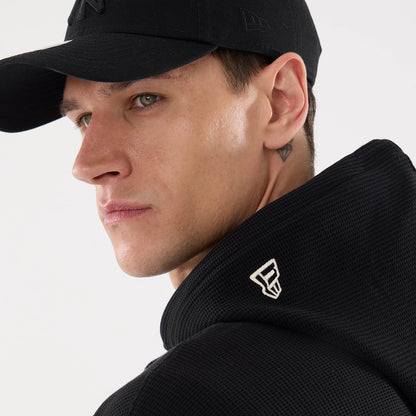 The model is wearing this New Era Waffle Full Zip Hoodie in black. 7