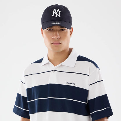 The model is wearing this New Era Stripe Polo T-Shirt in white. 5
