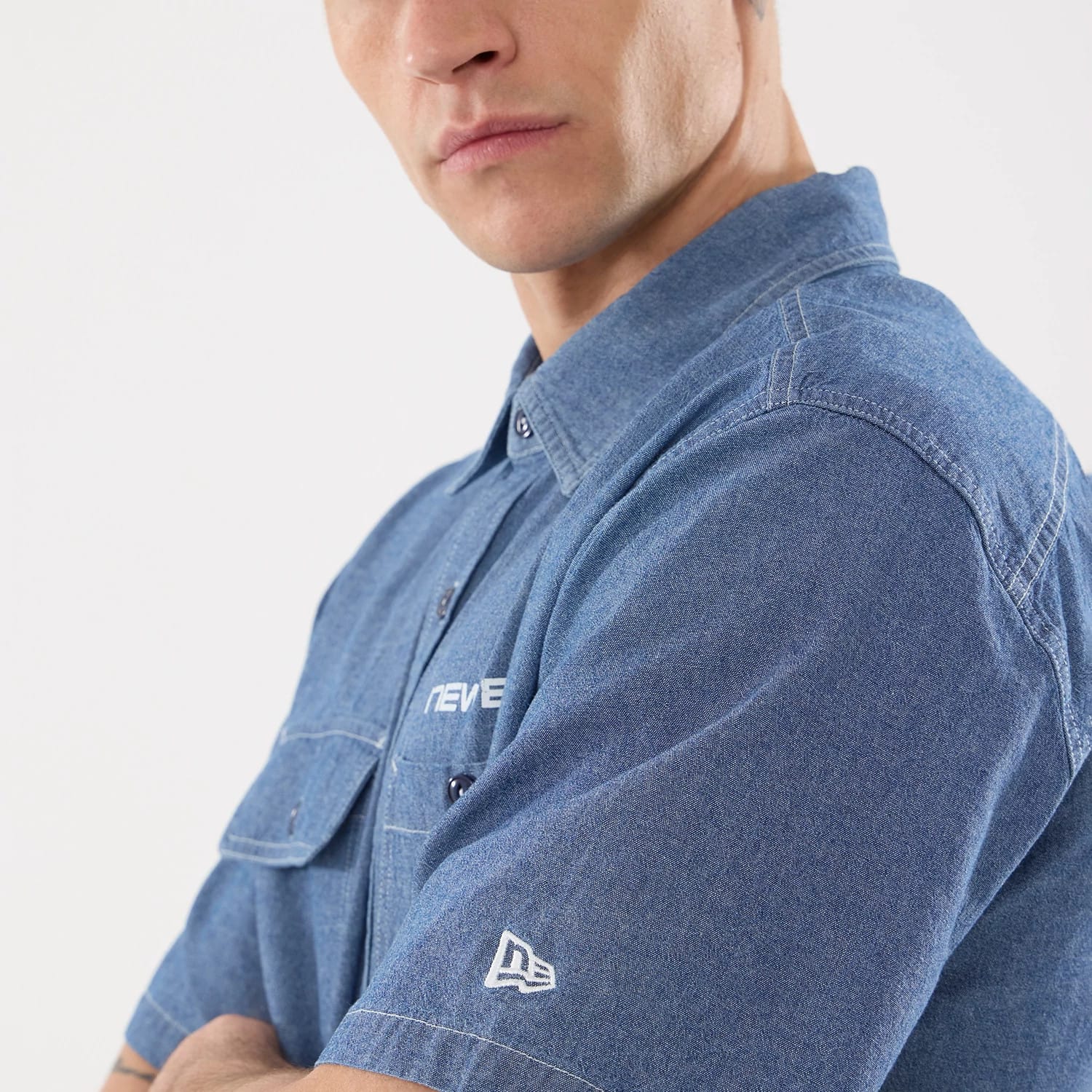 The model is wearing this New Era Originators Chambray Short Sleeve Shirt in dark blue. 5