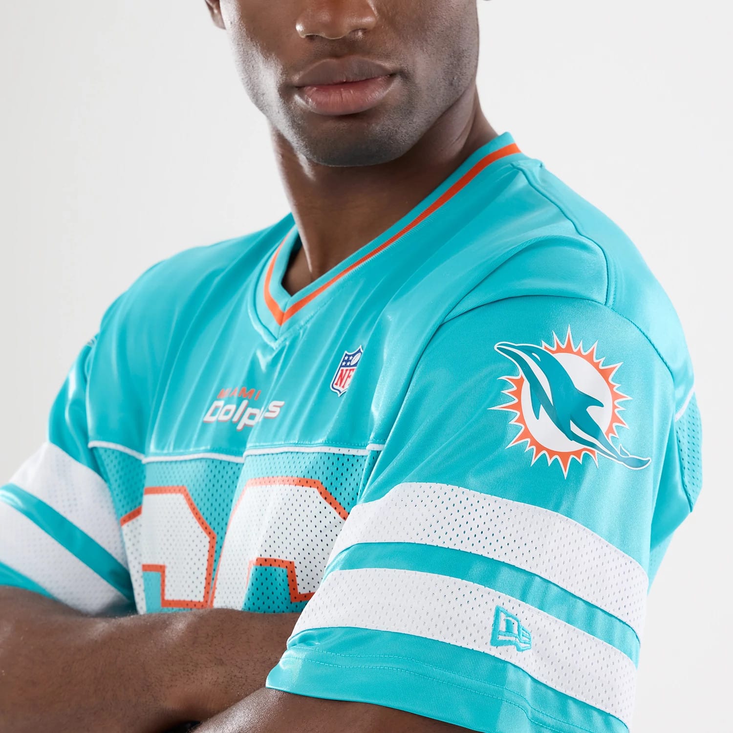 The model is wearing this NFL Miami Dolphins Mesh Jersey in turquoise. 3