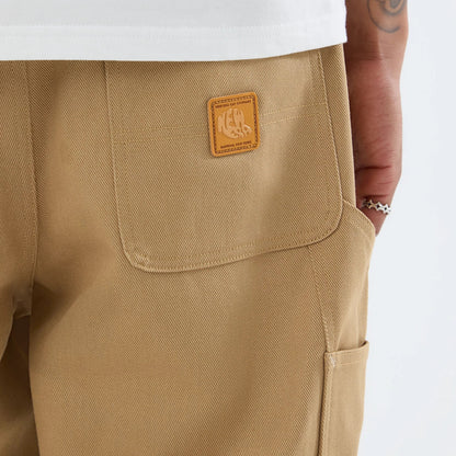 The model is wearing these New Era Work Pants in beige. 6