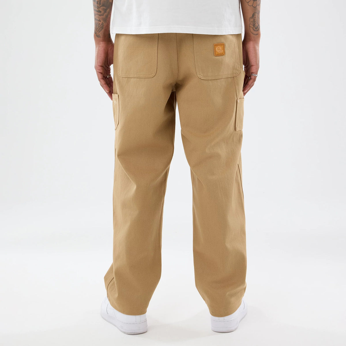 The model is wearing these New Era Work Pants in beige. 2