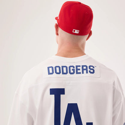 Los Angeles Dodgers MLB Fan Family White Jersey, back view on a model wearing a red cap, showing blue DODGERS lettering across the upper back and large LA lettering below on the white fabric.