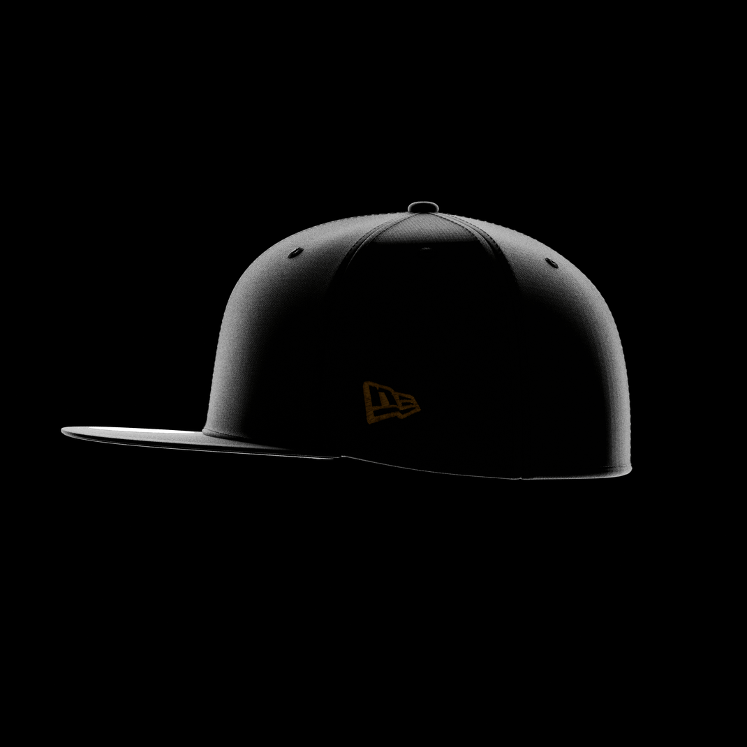 A black 59FIFTY cap shown in side profile against a solid black background, featuring a subtle tonal New Era Flag on the side and a structured flat brim.