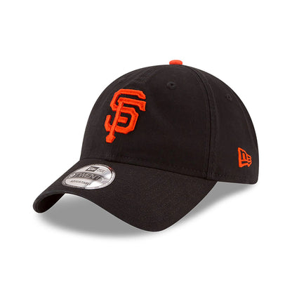 San Francisco Giants MLB Core Classic Black New Era 9TWENTY Adjustable Cap, three-quarter view with an orange embroidered SF logo on the front panel, curved visor, 9TWENTY size sticker on top, and New Era flag logo on the left side.