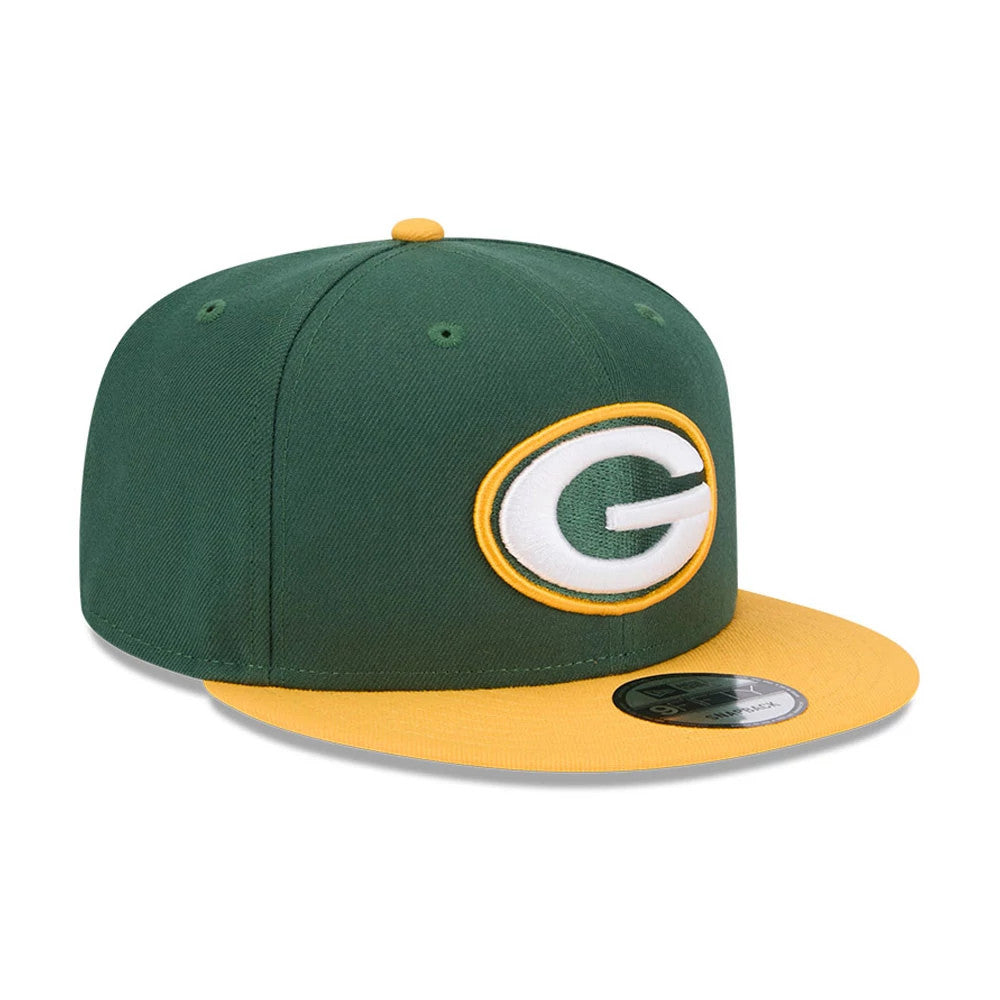 Green Bay Packers NFL Evergreen Dark Green New Era 9FIFTY Snapback Adjustable Cap, three-quarter view showing the raised embroidered G logo on the front panel, contrasting yellow visor, top button, and black 9FIFTY size sticker.
