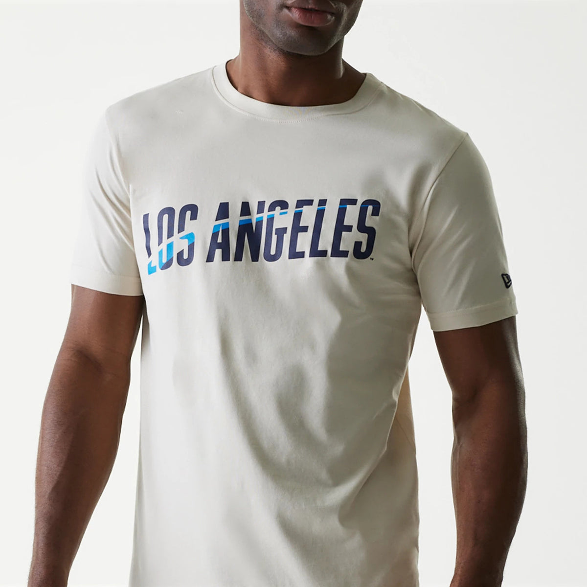 New Era LA Dodgers MLB City Connect Cream T-Shirt, front view showing blue and white Los Angeles text across the chest and a small debossed New Era logo on the left sleeve near the hem.