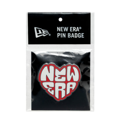 New Era Heart Silver Pin Badge, front view showing a heart-shaped design with raised white letters outlined in red spelling NEW ERA on a black background, encased in clear packaging with a branded header card at the top.