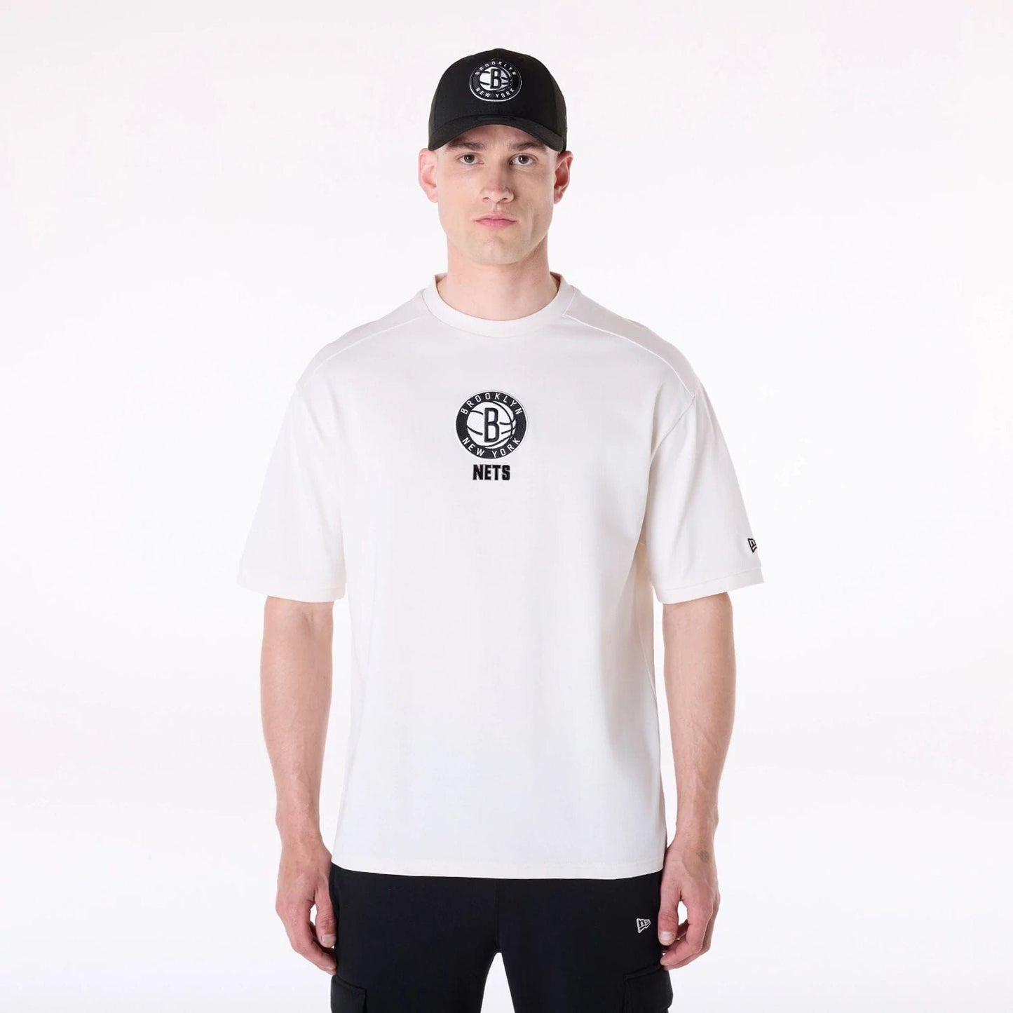 The Male model is wearing Brooklyn Nets NBA Wordmark Open White Oversized T-Shirt 1