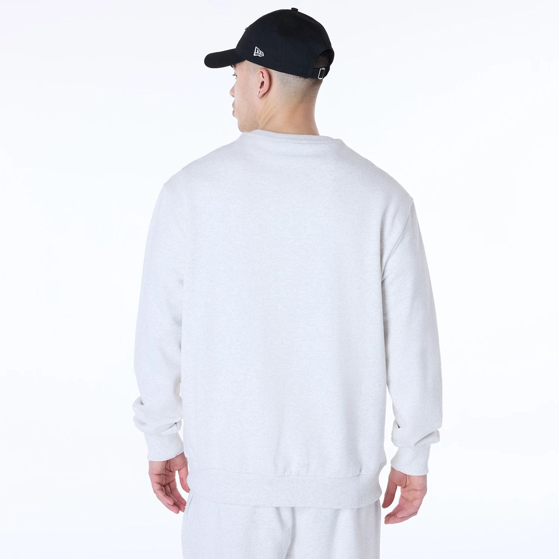 The Male model is wearing New Era Essential Pastel Grey Crew Neck Sweater 2